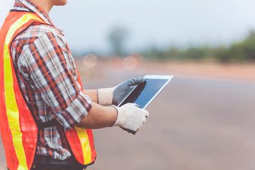Asian engineer with hardhat using tablet inspecting and working at construction site © nikomsolftwaer