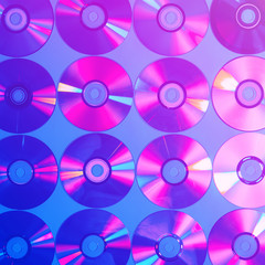 CDs on a plain background illuminated with neon light pink blue, minimal style