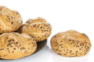 Group of four whole arranged sesame kaiser roll on gray ceramic plate isolated on white background