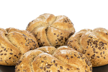 Group of four whole sesame kaiser roll on gray ceramic plate isolated on white background