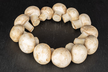 Lot of whole fresh white champignon on grey stone