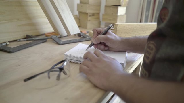 Close up shot of craftsman sketching a project design in his workshop