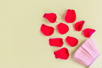 Valentine's day flat lay with a brush and rose petals on green background. Minimalism, creative concept, copy space