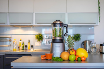 Making green smoothies with blender in home kitchen, healthy eating lifestyle concept