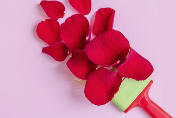 Valentine's day flat lay with a brush and rose petals on pink background. Minimalism, creative concept, copy space