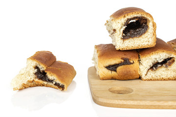 Group of four whole baked sweet czech bun on bamboo cutting board isolated on white background