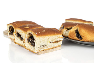 Lot of whole sweet czech bun on wooden cutting board on gray ceramic plate isolated on white background