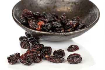 Lot of whole sweet dried cowberry................ in glazed bowl isolated on white background