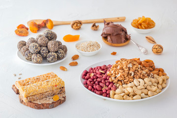 Bars of sports nutrition from nuts, seeds and chocolate paste - vegetable natural protein, a mixture of dried fruits, assorted nuts and seeds on a bright table