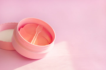 Can hydrogel cosmetic eye patch for skin care on pink background. Product for face lifting, anti-aging wrinkles, copy space