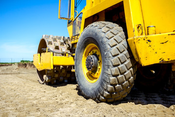 Road roller with spikes is working at construction site