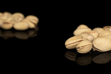 Lot of whole arranged salted pistachio isolated on black glass