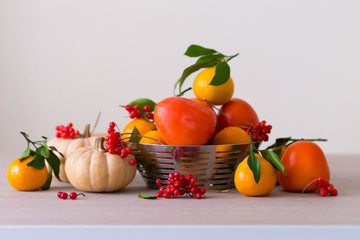 Food. Tangerines, viburnum, pumpkin, persimmon in table