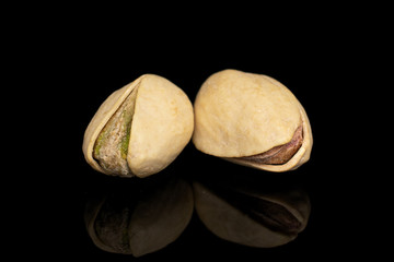 Fototapeta na wymiar Group of two whole salted pistachio isolated on black glass