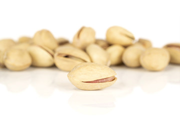 Lot of whole salted pistachio front focus isolated on white background