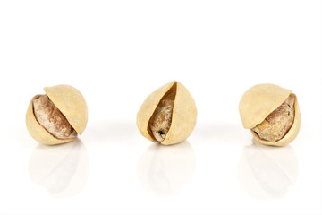 Group of three whole salted pistachio isolated on white background