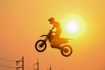 Fototapeta na wymiar Practice day,silhouette of a motorcycle motocross jumping on sunset background.