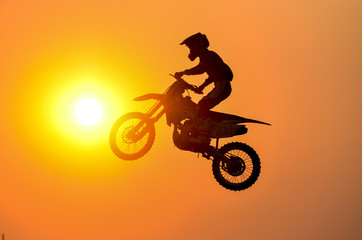 Practice day,silhouette of a motorcycle motocross jumping on sunset background.