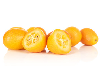 Group of three whole two halves of tasty orange kumquat isolated on white background