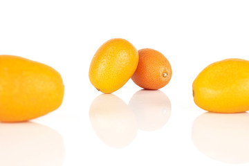 Group of four whole tasty orange kumquat isolated on white background