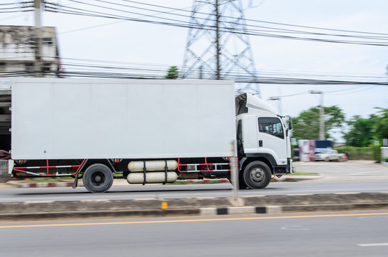 Motion image, small white truck for logistics on the road.