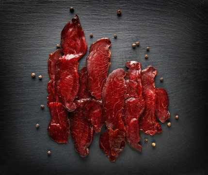 beef jerky, bresaola, basturma on a black background