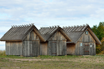 Fototapeta na wymiar Three wooden sheds by the sea