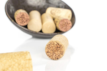 Lot of whole common wine cork in glazed bowl isolated on white background