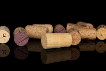 Lot of whole disordered common wine cork isolated on black glass