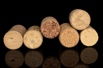 Group of six whole common wine cork isolated on black glass