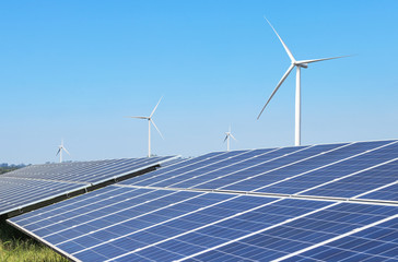 Solar panels and wind turbines generating electricity is solar energy and wind energy in hybrid power plant systems station use renewable energy to generate electricity with blue sky  - 306680912