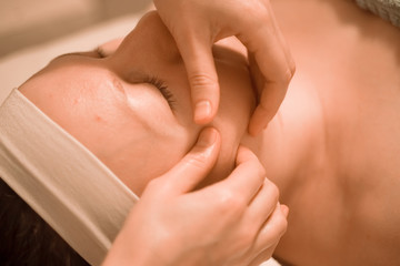 Beautiful plus size middle age woman getting a face massage treatment at beauty salon. close up step by step