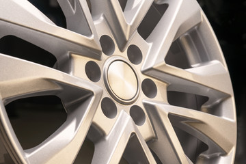 new powerful silver aluminum rim wheel for suv cars original on black background . beautiful concept, close-up. shot in a tire shop