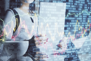 Double exposure of hands making notes with forex chart huds. Stock market concept.