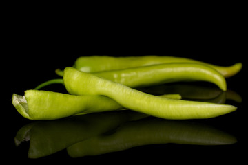 Group of two whole two halves of hot green pepper banana isolated on black glass