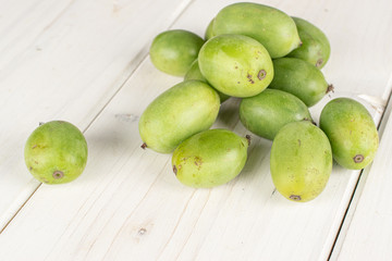 Lot of whole hardy green kiwi on white wood