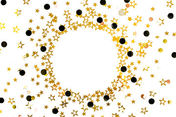 Round frame of gold stars confetti, glitter decoration on a white, festive background. Christmas or New Year pattern. Flat lay, top view