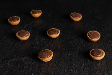 Group of eight whole sweet brown toffee on grey stone