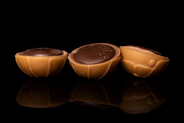 Group of three whole sweet brown toffee isolated on black glass