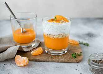 healthy chia pudding with mandarin in a glass. light gray background. horizontal image