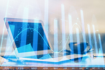 Stock market graph on background with desk and personal computer. Double exposure. Concept of financial analysis.