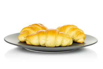 Group of three whole sweet golden mini croissant on gray ceramic plate isolated on white background