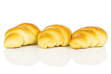 Group of three whole sweet golden mini croissant in row isolated on white background