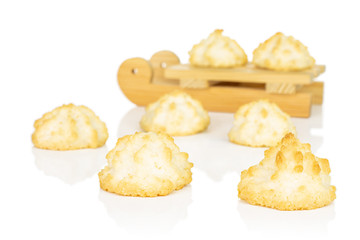 Lot of whole homemade golden coconut biscuit with wooden sledge isolated on white background