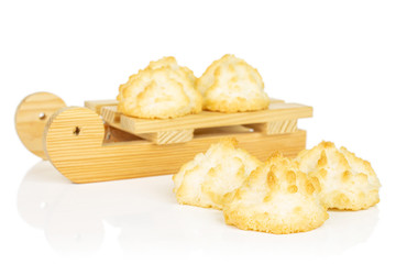 Group of six whole homemade golden coconut biscuit with wooden sledge isolated on white background