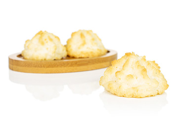 Group of three whole homemade golden coconut biscuit on bamboo coaster isolated on white background