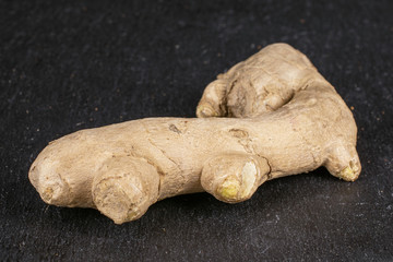 Fototapeta premium One whole fresh brown ginger on grey stone