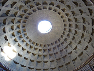 Innenansicht der Kassettendecke des Pantheons in Rom mit Lichtschein durch die kreisförmige Öffnung in der Kuppel 