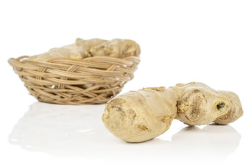 Group of two whole fresh brown ginger in round rattan bowl isolated on white background