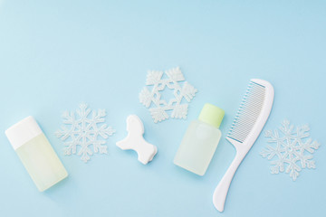 Baby bath winter products on blue background with snow decor. body care products for children